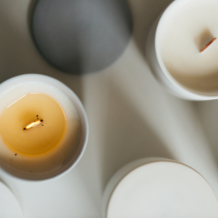 Clean burning candles made with coconut and apricot wax on a minimalist white surface