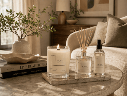 Upsensed Moss candle, reed diffuser, and room spray styled on a marble coffee table in a warm modern living room.