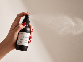 Three Upsensed room + linen sprays — Nocturne, Cloudwash, and Undertow — displayed together on a warm stone surface with a linen cloth, dried floral stem, and smooth stone.