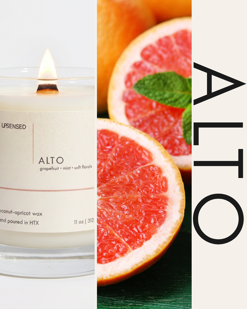 Upsensed Alto candle with a lit wooden wick beside fresh grapefruit and mint to highlight its citrus floral scent profile.