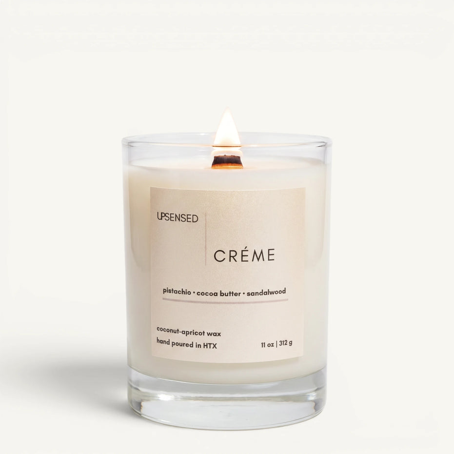 Upsensed Creme 11oz scented candle burning with wood wick - pistachio cocoa butter and sandalwood coconut apricot wax candle hand poured in Houston
