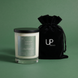 Upsensed Higher Ground 11oz scented candle with black velvet drawstring gift bag on sage green background - petrichor moss and rainwater coconut apricot wax candle hand poured in Houston