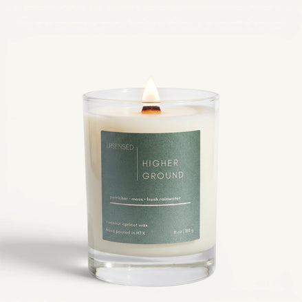 Upsensed Higher Ground 11oz scented candle burning with wood wick - petrichor moss and fresh rainwater coconut apricot wax candle hand poured in Houston