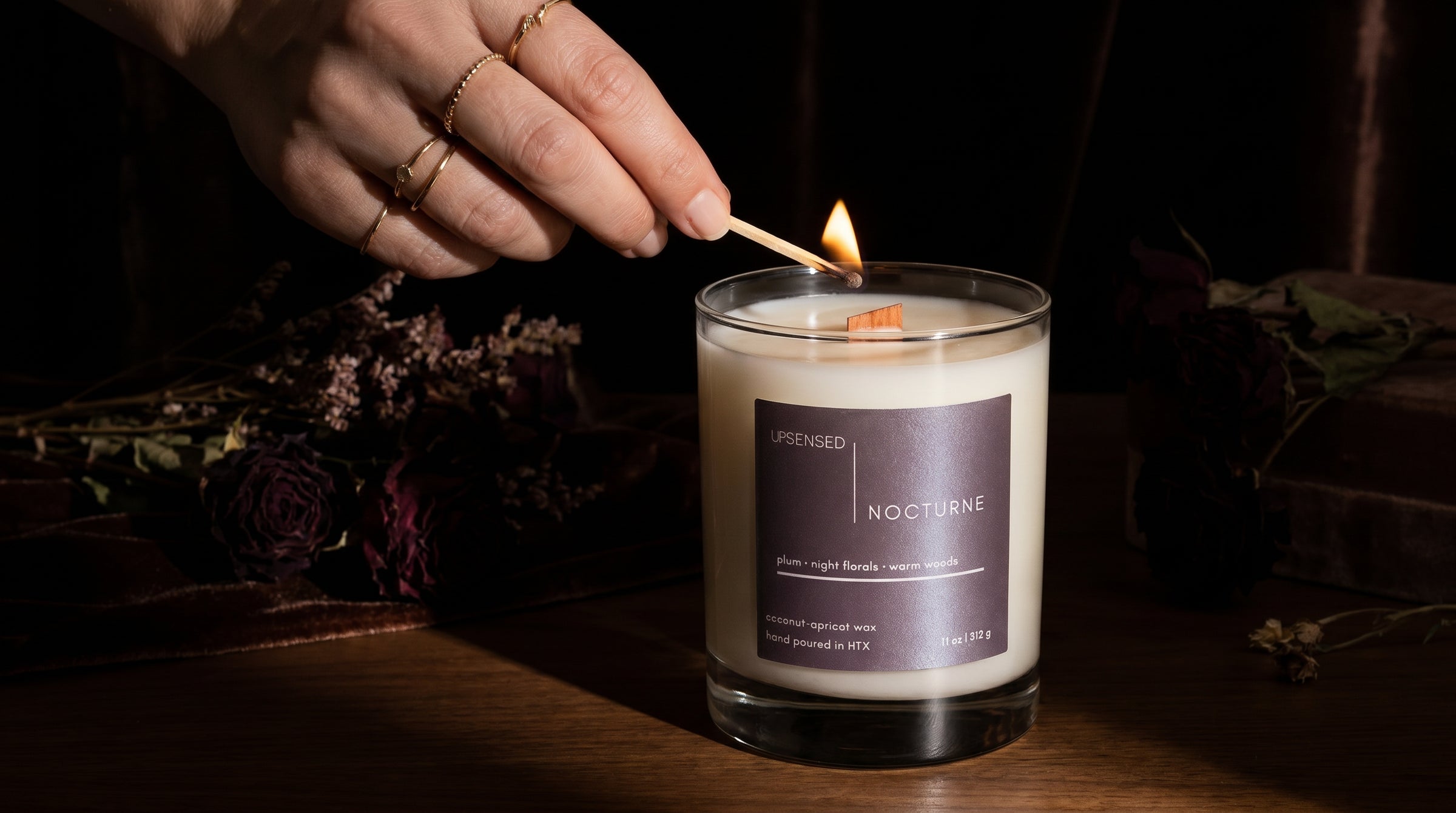 Nocturne candle being lit by hand — coconut apricot wax wooden wick candle by Upsensed
