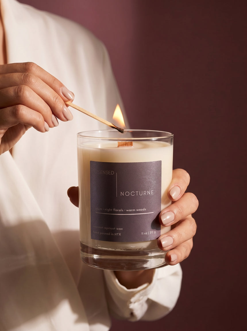 woman lighting a wooden wick candle — Upsensed Nocturne non-toxic home fragrance
