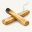 Crossed palo santo wood sticks with smoke rising from one charred end.