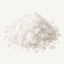A pile of coarse sea salt crystals on a plain off-white background.
