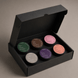Upsensed Candle Discovery Set gift box open, showing 6 mini candles nestled inside — Higher Ground, Lignum, Intention, Veil, Nocturne, and Alto 2 oz coconut-apricot wax candles in matte black tins, hand poured in Houston