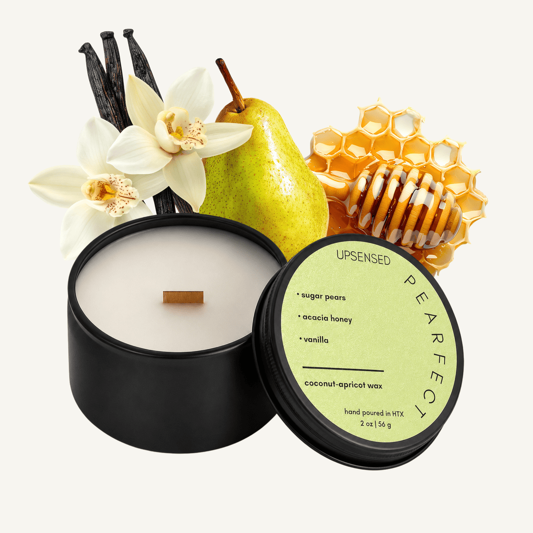 Upsensed Pearfect 2 oz mini candle in a matte black tin with soft sage green lid, surrounded by a fresh green pear, honeycomb with honey drizzle, and white vanilla orchid with vanilla beans