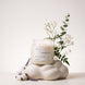 Upsensed Cloudwash candle burning atop a cloud-shaped ceramic sculpture, styled with jasmine and eucalyptus branches, cotton bolls, and sprigs of lavender.