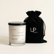 Upsensed Cloudwash candle beside reusable black velvet drawstring gift bag on cream background