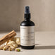 Upsensed Creme Room and Linen Spray beside pistachios raw cocoa butter and sandalwood sticks - warm gourmand home fragrance hand poured in Houston
