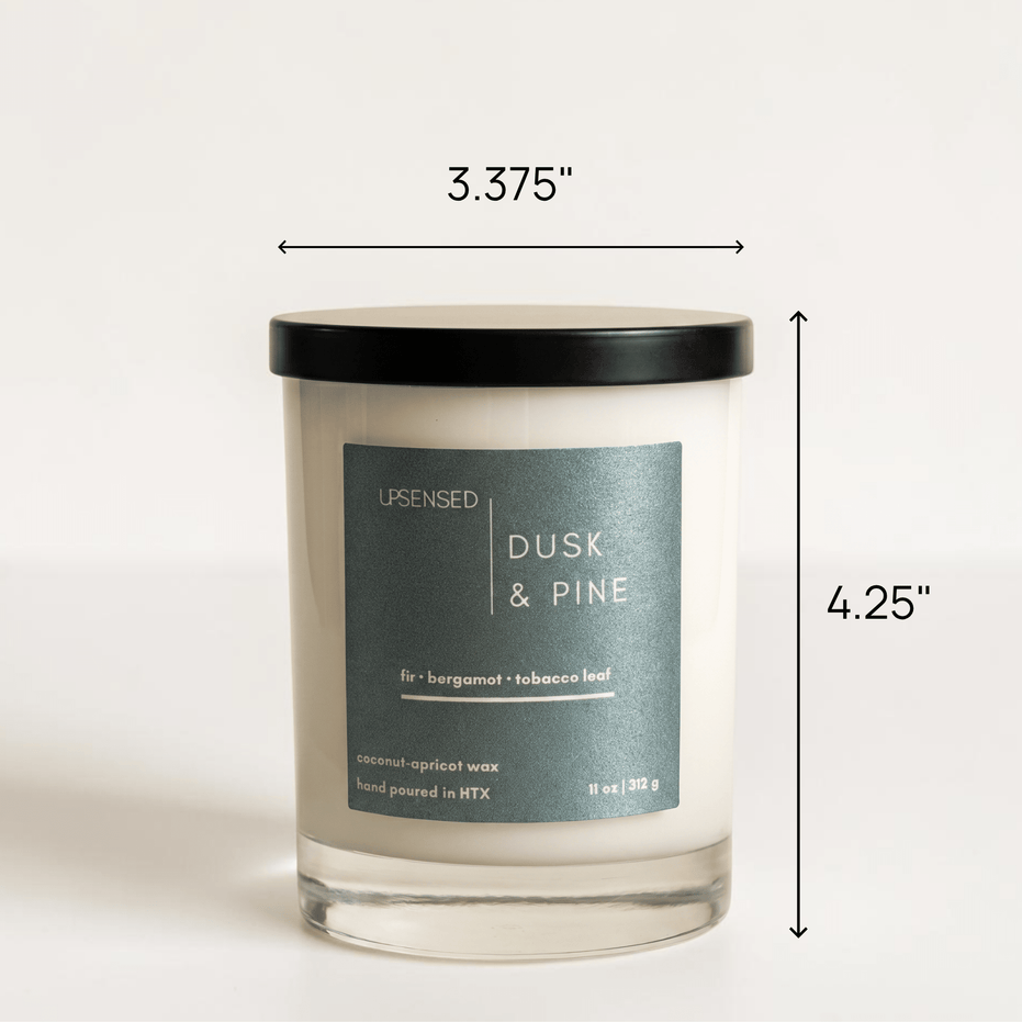 Upsensed Dusk & Pine candle with black lid showing dimensions — 3.375 inches wide by 4.25 inches tall