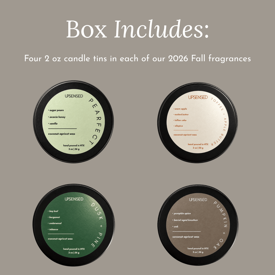 A product graphic showing four round candle tins arranged in a 2x2 grid under the heading 'Box Includes:'. The text says the box includes four 2 oz candle tins in each of the 2026 Fall fragrances.
