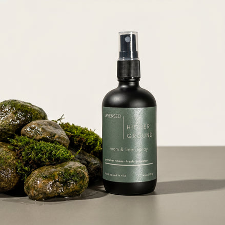 Upsensed Higher Ground Room and Linen Spray surrounded by moss-covered wet stones - petrichor and rainwater home fragrance hand poured in Houston