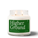 Higher Ground 18 oz double-wick soy candle by Upsensed, both wicks lit, in a clear glass jar with a forest green label listing petrichor, cedarwood, and fresh rainwater notes.
