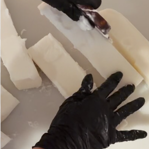Instagram post from @upsensed — hands in black gloves handling blocks of coconut-apricot wax during the candle-making process
