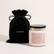 Upsensed Intention candle with a black lid beside its black velvet UPSENSED drawstring packaging bag, on a cream background.