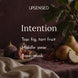 Intention soy candle fragrance notes: fig and tart fruit on top, pear in the middle, and musk at the base, shown with fresh figs, ripe pears, and red currants on plum linen with a soft cream cloth.