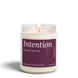 Intention 8 oz soy candle by Upsensed, lit, in a clear glass jar with a pink label listing fig, pear, and tart fruit notes.