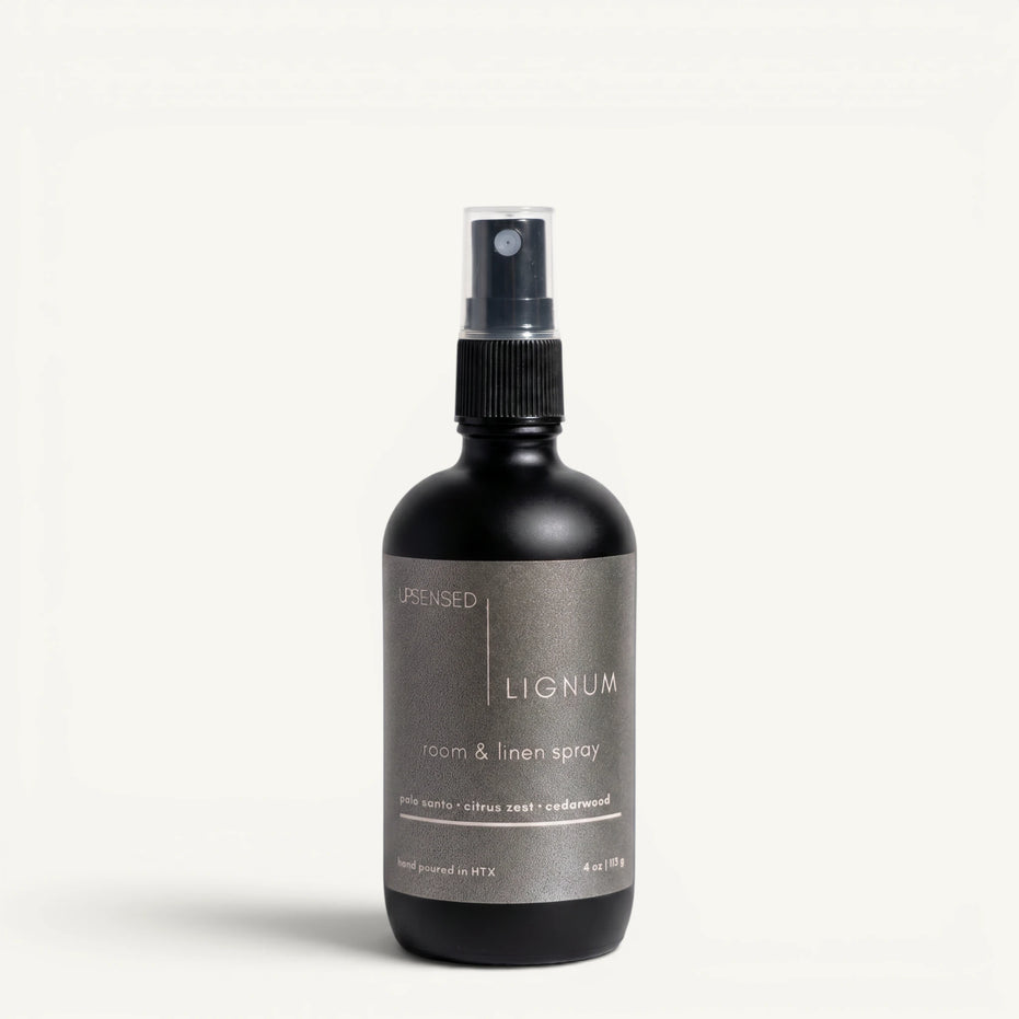 Upsensed Lignum 4oz Room and Linen Spray in matte black bottle with charcoal label - palo santo citrus zest and cedarwood linen spray