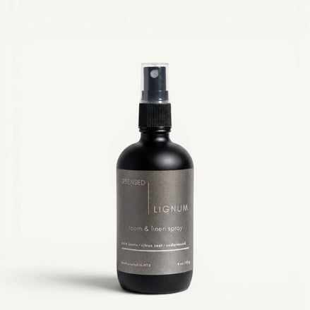 Upsensed Lignum 4oz Room and Linen Spray in matte black bottle with charcoal label - palo santo citrus zest and cedarwood linen spray