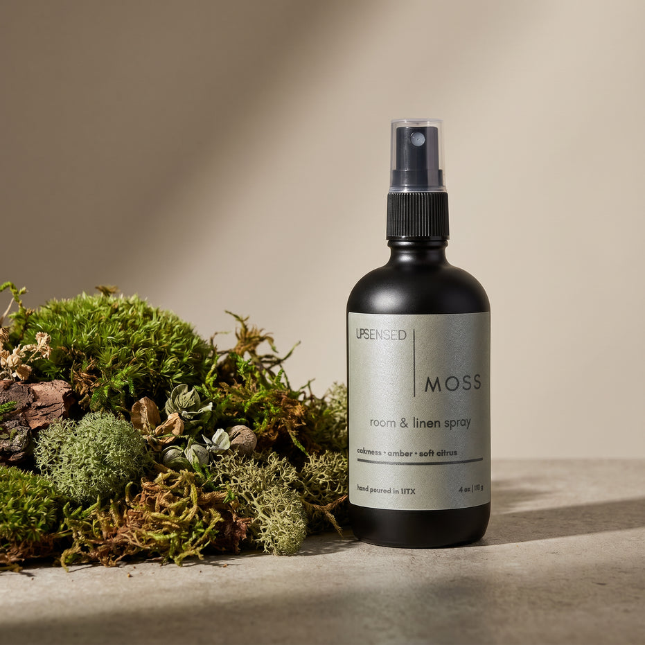 Upsensed Moss Room and Linen Spray beside fresh oakmoss and botanical botanicals - earthy amber home fragrance hand poured in Houston