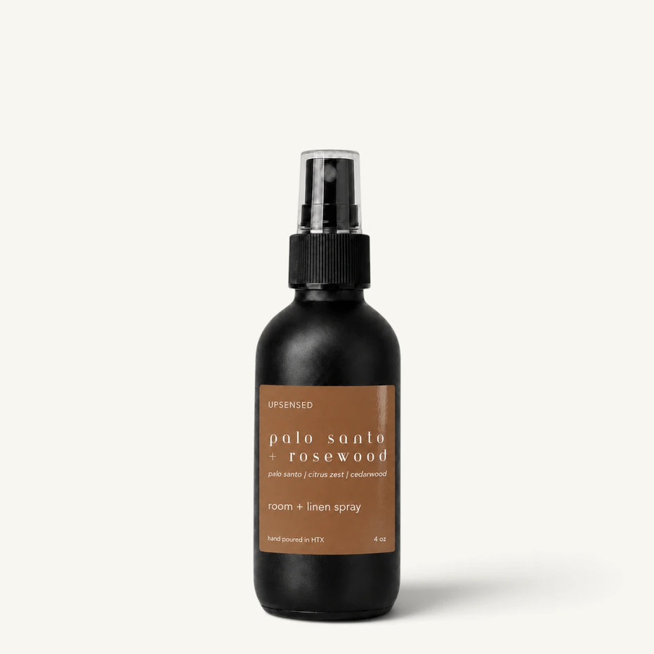 Upsensed Palo Santo + Rosewood room and linen spray in a matte black 4 oz bottle with warm brown label