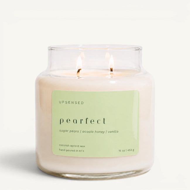 Upsensed Pearfect 16 oz double-wick candle in a clear apothecary jar with a pale green label, sugar pears, acacia honey, and vanilla scent notes, on a plain white background.