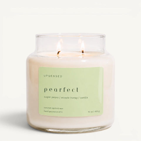 Upsensed Pearfect 16 oz double-wick candle in a clear apothecary jar with a pale green label, sugar pears, acacia honey, and vanilla scent notes, on a plain white background.