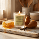 Upsensed Pearfect candle burning on a marble board in a warm kitchen setting surrounded by honeycomb and bosc pears