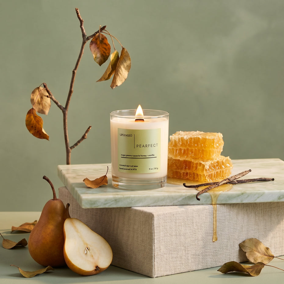 Upsensed Pearfect gourmand candle styled with fresh pears, honeycomb, and vanilla beans on a marble surface with sage green background