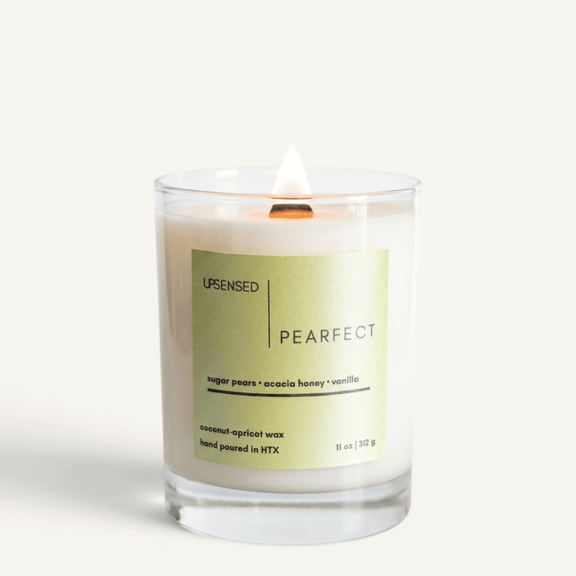 Upsensed Pearfect candle lit on white background, showing sage green label with sugar pear, acacia honey, and vanilla notes