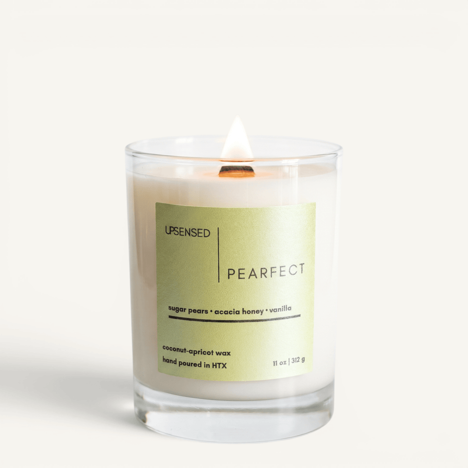 Upsensed Pearfect candle lit on white background, showing sage green label with sugar pear, acacia honey, and vanilla notes