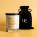 Upsensed Sunward candle beside reusable black velvet drawstring gift bag on warm golden background