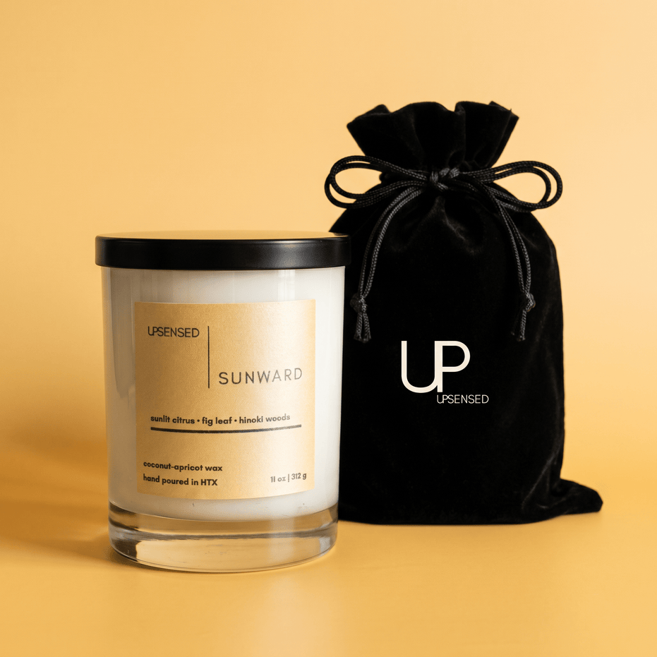 Upsensed Sunward candle beside reusable black velvet drawstring gift bag on warm golden background