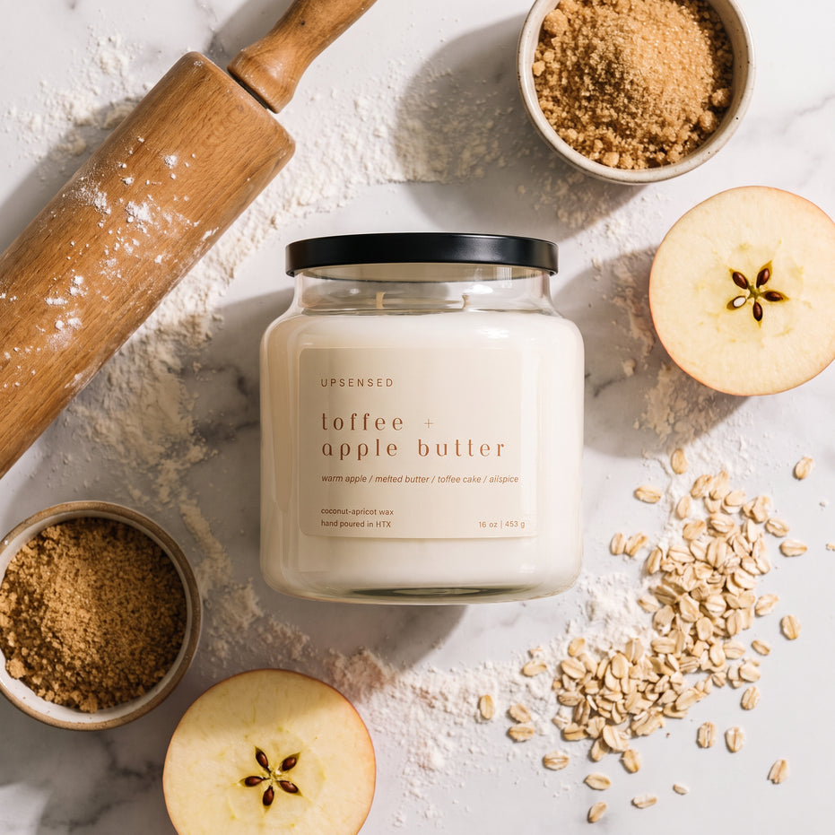 Upsensed Toffee + Apple Butter fall candle styled with sliced apples, brown sugar, oats, flour, and a wooden rolling pin.