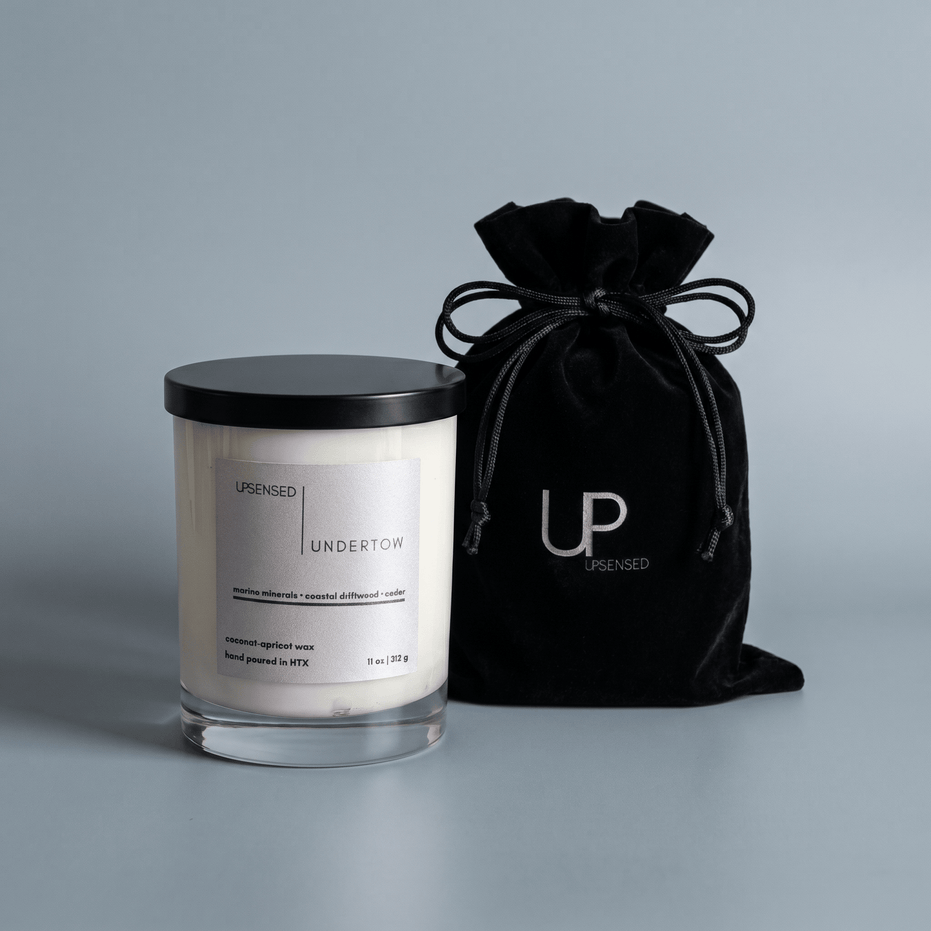 Upsensed Undertow candle beside reusable black velvet drawstring gift bag on steel blue background
