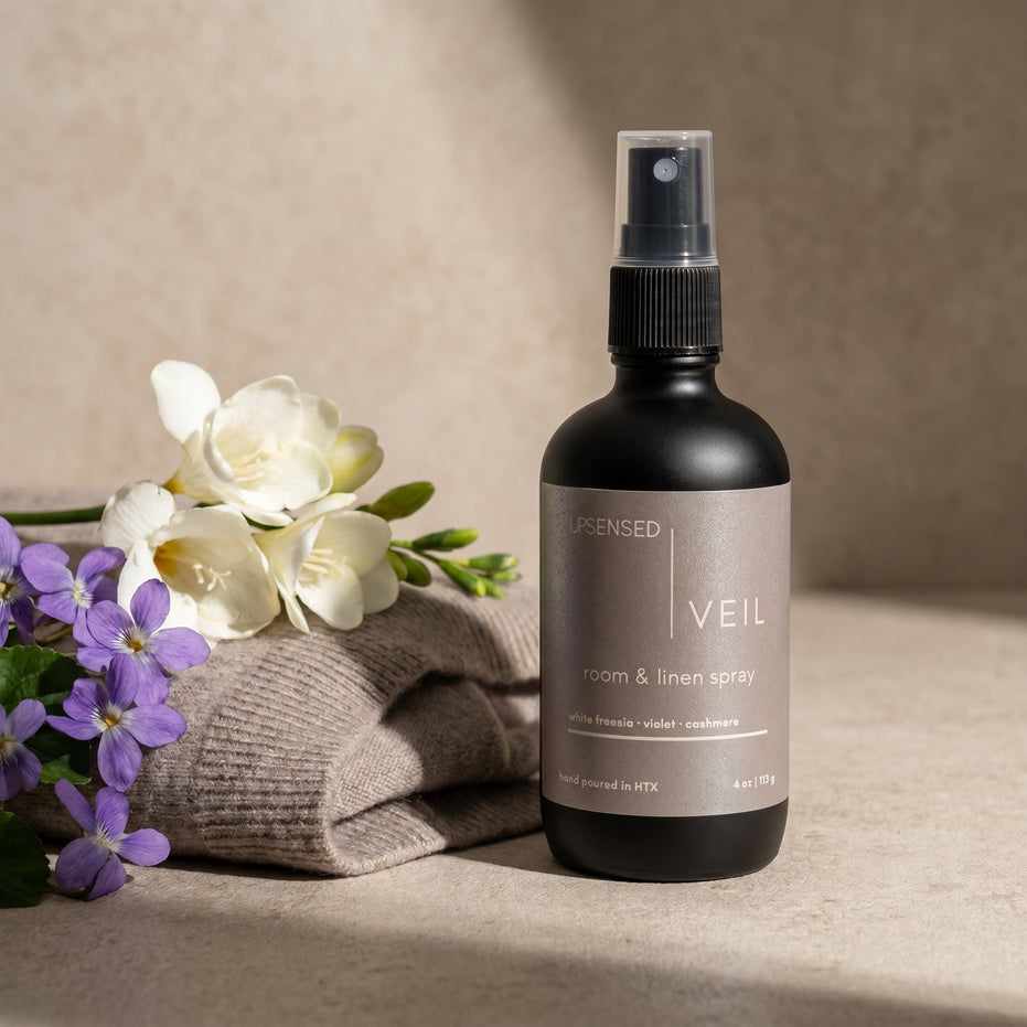Upsensed Veil room and linen spray with white freesia, violet, and soft cashmere on a warm neutral surface