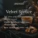Velvet Spruce fragrance notes graphic over snowy spruce branches, a ramekin of crème brûlée, vanilla beans, pine cones, amber resin, and sandalwood on dark green velvet. Top notes piñon pine, cracked peppercorn, toasted coconut; middle notes cedarwood, forest moss, whipped vanilla; base notes sandalwood, amber, soft suede.