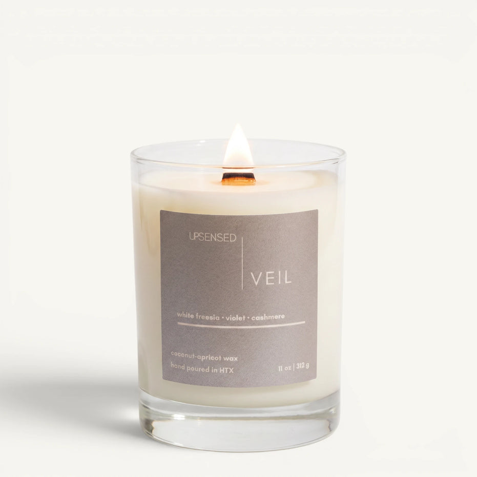 Upsensed Veil 11oz scented candle burning with wood wick - white freesia violet and cashmere coconut apricot wax candle hand poured in Houston