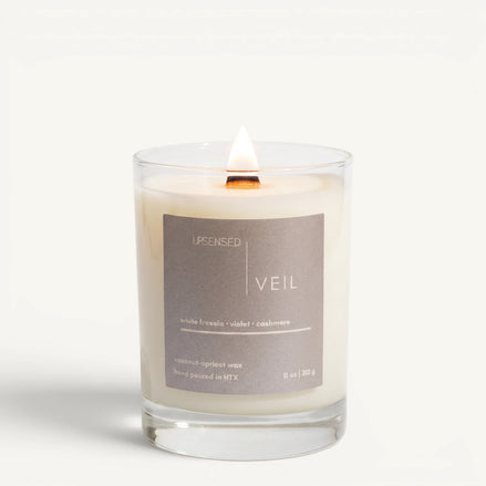 Upsensed Veil 11oz scented candle burning with wood wick - white freesia violet and cashmere coconut apricot wax candle hand poured in Houston